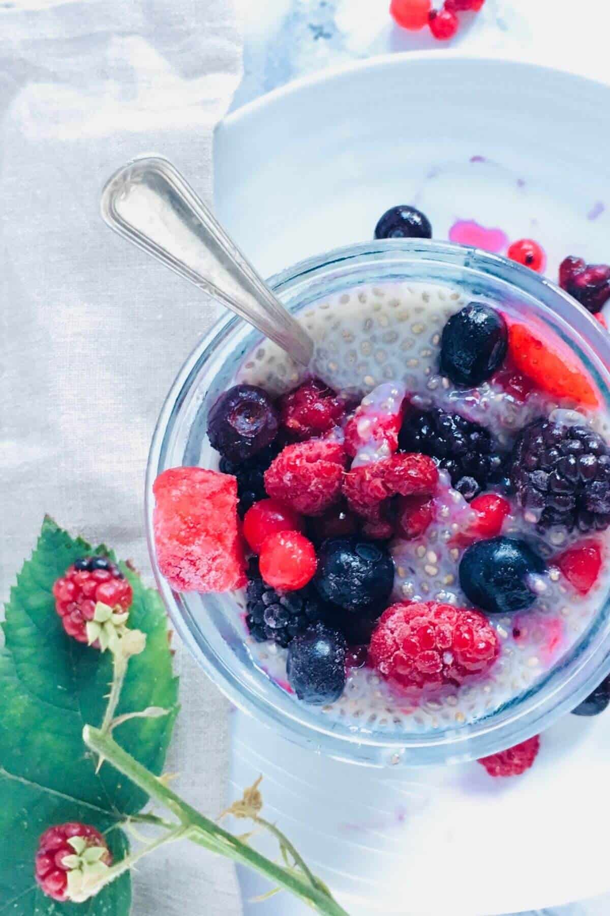 A glass filled with chia pudding and fresh berries.