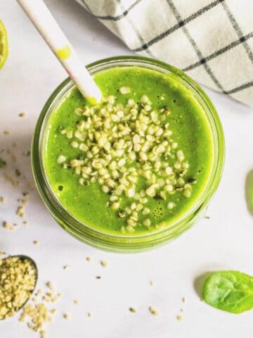 A glass of green smoothie topped with hemp seeds.
