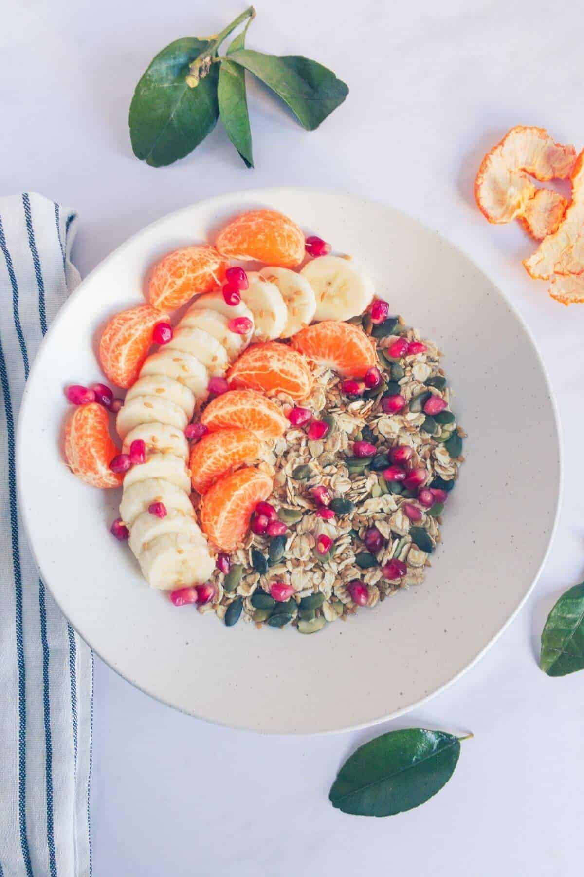 Rolled oats topped with pumpkin and pomegranate seeds, sliced banana and satsuma segments.