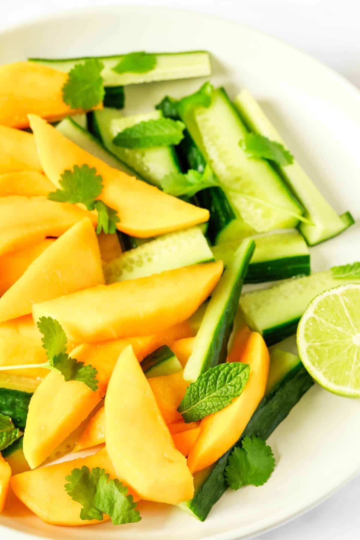 Cucumber and mango slices with fresh herbs.