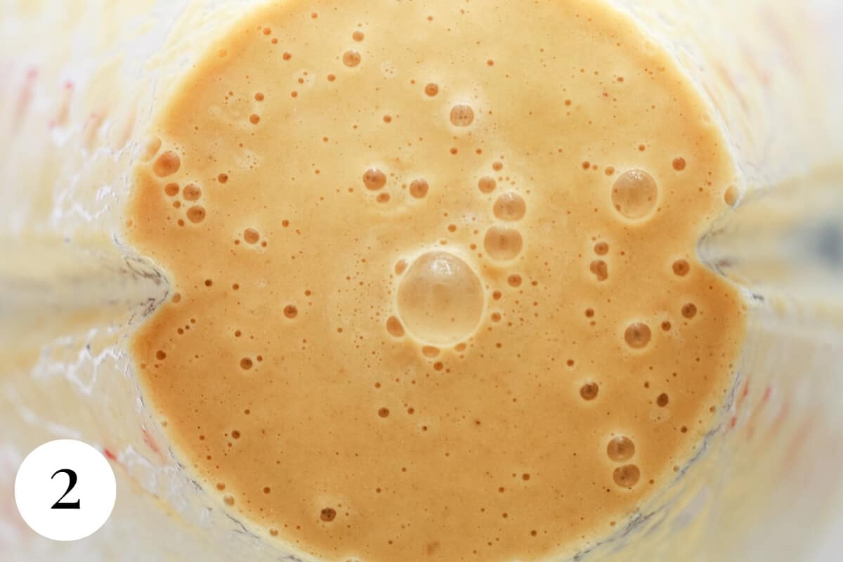 Close up, top down view of a bubbling creamy caramel coloured liquid in a glass dish.
